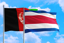 Costa Rica And Afghanistan National Flag Waving In The Wind On A Deep Blue Sky Together. High Quality Fabric. International Relations Concept.
