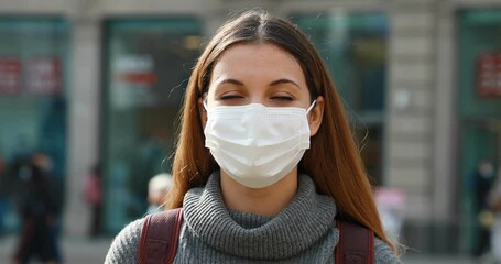 Wall Mural - Close up portrait of young woman with protective mask on her face in street of Milan, Italy