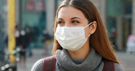 Wall Mural - Close up of pretty girl with surgical mask in the city waiting public transport