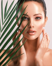 Young Beautiful Woman With Green Leaves Near Body. Skin Care Beauty Treatments Concept.  Closeup Girl's Face With Green Leaves.