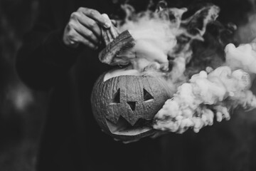 Poster - Grayscale shot of a carved pumpkin with smoke coming out of it - the concept of Halloween