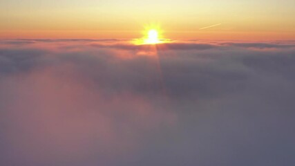 Wall Mural - crossing the clouds during sunrise, aerial flight above clouds during golden hour in sunrise light.