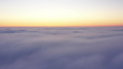 Wall Mural - crossing the clouds during sunrise, aerial flight above clouds during golden hour in sunrise light.