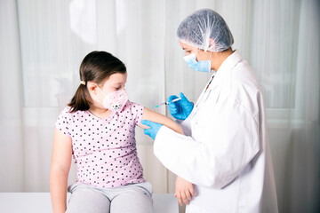 Vaccination concept. Female doctor vaccinating cute little girl in clinic.