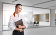 © ImageFlow - Young businesswoman with folder in office