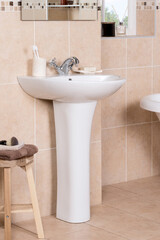 Canvas Print - Vertical shot of a white modern pedestal bathroom sink with soap and toothbrush