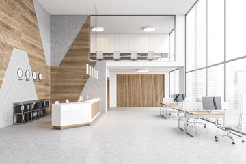 Reception desk in open space lobby with clocks, tables with computers