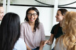 © fizkes - Warm workplace relations. Happy diverse multiethnic corporate staff chatting communicating on team briefing in office, laughing on good joke, having funny moment in work talk conversation discussion
