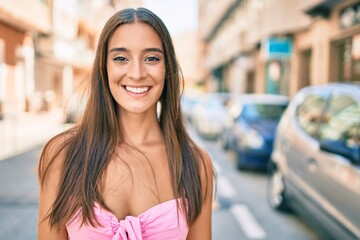 Wall Mural - Young hispanic woman smiling happy walking at street of city.