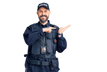 Poster - Young handsome man wearing police uniform amazed and smiling to the camera while presenting with hand and pointing with finger.