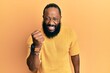 © Krakenimages.com - Young african american man wearing casual clothes angry and mad raising fist frustrated and furious while shouting with anger. rage and aggressive concept.