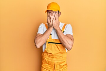 Canvas Print - Young handsome man wearing handyman uniform over yellow background rubbing eyes for fatigue and headache, sleepy and tired expression. vision problem