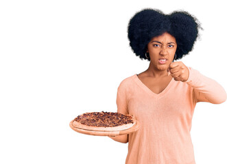 Wall Mural - Young african american girl holding italian pizza annoyed and frustrated shouting with anger, yelling crazy with anger and hand raised