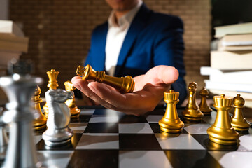 Wall Mural - close up business man formal suit hand hold king figure chess board game business stratey organize and management ideas concept