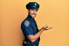 Handsome Hispanic Man Wearing Police Uniform Pointing Aside With Hands Open Palms Showing Copy Space, Presenting Advertisement Smiling Excited Happy