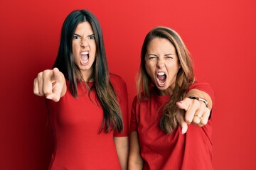 Sticker - Hispanic family of mother and daughter wearing casual clothes over red background pointing displeased and frustrated to the camera, angry and furious with you