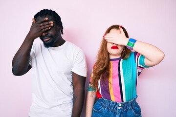 Poster - Interracial couple wearing casual clothes covering eyes with hand, looking serious and sad. sightless, hiding and rejection concept