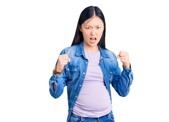 Poster - Young beautiful chinese woman pregnant expecting baby angry and mad raising fists frustrated and furious while shouting with anger. rage and aggressive concept.