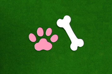 The bone is white, the paw print is pink on a green background. Pet, veterinary medicine. pet supplies.