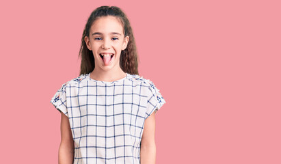 Cute hispanic child girl wearing casual clothes sticking tongue out happy with funny expression. emotion concept.