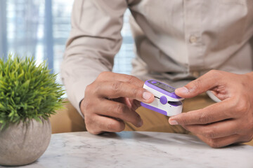  young man hand using pulse oximeter