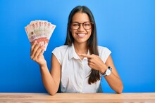 Beautiful Hispanic Woman Holding 10 United Kingdom Pounds Banknotes Smiling Happy Pointing With Hand And Finger