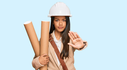 Canvas Print - Beautiful hispanic woman holding paper blueprints with open hand doing stop sign with serious and confident expression, defense gesture