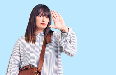 Sticker - Young plus size woman wearing leather bag with open hand doing stop sign with serious and confident expression, defense gesture