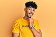 © Krakenimages.com - Young arab handsome man wearing tshirt with happiness word message smiling looking confident at the camera with crossed arms and hand on chin. thinking positive.