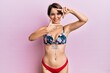 © Krakenimages.com - Young brunette woman with short hair wearing bikini showing tattoos smiling making frame with hands and fingers with happy face. creativity and photography concept.