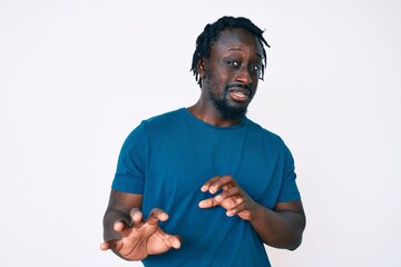 Canvas Print - Young african american man with braids wearing casual clothes disgusted expression, displeased and fearful doing disgust face because aversion reaction. with hands raised