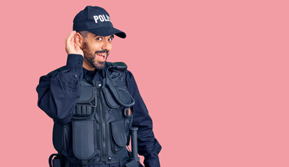 Sticker - Young hispanic man wearing police uniform smiling with hand over ear listening an hearing to rumor or gossip. deafness concept.