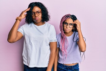 Poster - Beautiful african american mother and daughter wearing casual clothes and glasses worried and stressed about a problem with hand on forehead, nervous and anxious for crisis