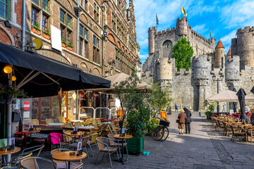 Wall Mural - Old street with tables of cafe in Ghent (Gent), Belgium. Architecture and landmark of Ghent. Cozy cityscape of Ghent.
