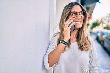 Young caucasian woman smiling happy talking on the smartphone at the city.