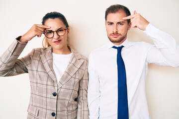 Beautiful couple wearing business clothes pointing unhappy to pimple on forehead, ugly infection of blackhead. acne and skin problem