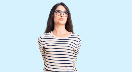 Wall Mural - Brunette teenager girl wearing casual clothes and glasses smiling looking to the side and staring away thinking.