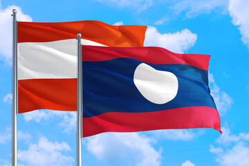 Laos and Austria national flag waving in the windy deep blue sky. Diplomacy and international relations concept.