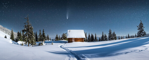 Wall Mural - fantastic winter landscape panorama with wooden house in snowy mountains. starry sky with milky way 
