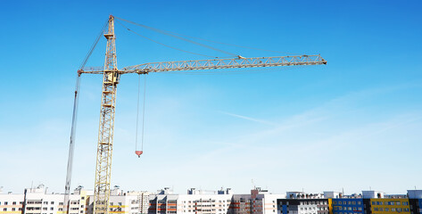 Construction crane on the background of the sky. Construction site.