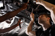 © alfa27 - two friendly professional auto mechanic during work, they are successfully repairing car, solve problems together
