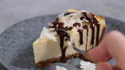 Wall Mural - Eating vegan coconut cashew cheesecake with a fork. Taking bite of cheesecake