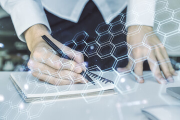 Poster - Creative concept of wireless technology with hexagon hologram and hand writing in notebook on background with laptop. Big data and database concept. Multiexposure