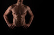 © Anetta - Muscular male torso of fit bodybuilder on black background