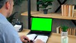 © viacheslav - Green screen laptop computer concept: Man student sitting on chair at table in home office study online remote distance learning education by web cam video call conference chat