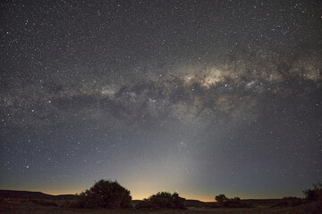 Stary sky with milky way across the frame sunrise and mointains in the dark background in Argentina Patagonia south America  