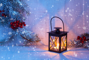 Canvas Print - Burning Christmas lantern and fir branches with red berries on rustic  wooden background  at the  evening.