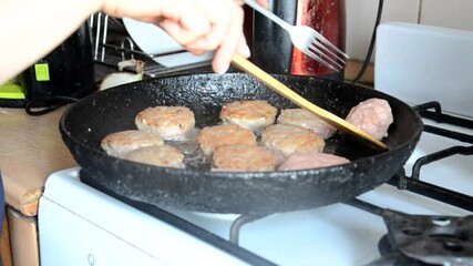 Wall Mural - cooking burger patties in a pan with butter. woman fries meatballs in oil on a hot pan. girl is cooking at home. quarantined food. Recipes and cooking. meatballs for burger meat cutlets in the kitchen