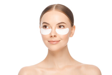 Portrait of young beautiful woman wearing eye patches to look fresher, looking away, isolated on white background