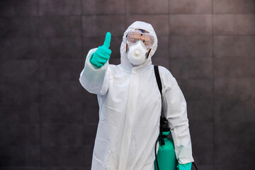 Wall Mural - Man in sterile protective uniform with rubber gloves carrying sp